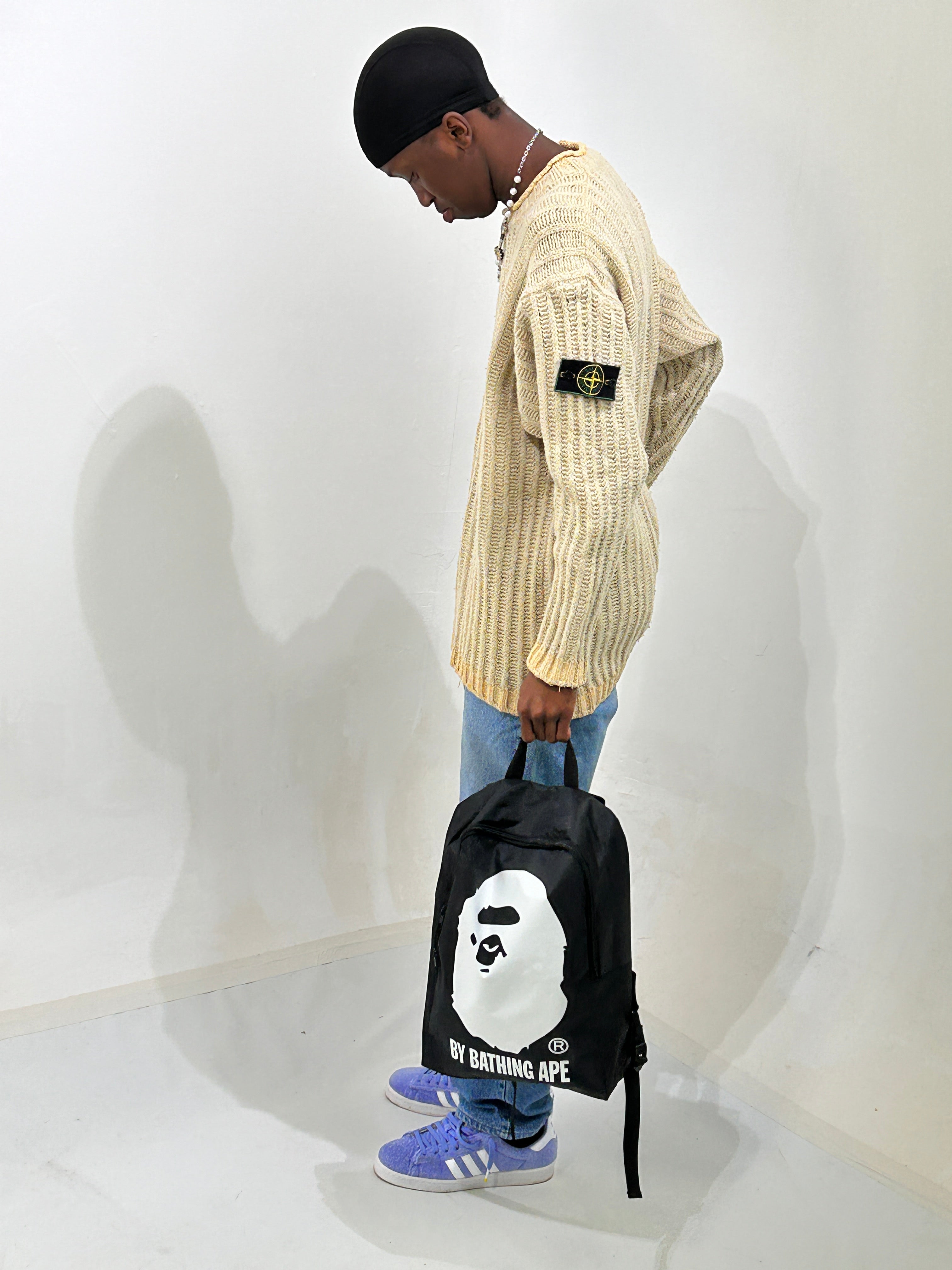 STONE ISLAND GREEN EDGE BADGE ON A THICK KNIT JUMPER, MODEL ALSO HOLDING A BAPE BACKPACK 